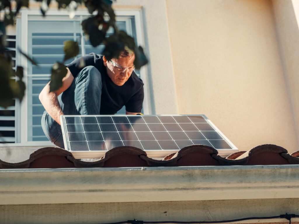 KW4AC Blog a man installing a solar panel on a roof